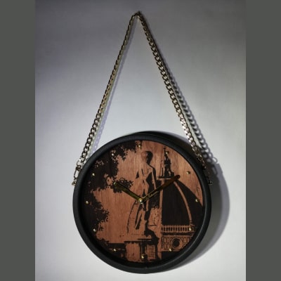 Orologio da parete unico con incisione laser del David e Duomo su legno di noce, lancette dorate e cornice in ecopelle nera. Perfetto come regalo e decorazione elegante.