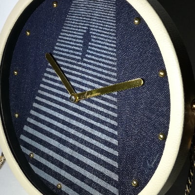 Particolare: Orologio da parete e scrivania in jeans inciso a laser con uomo che cammina. Design simbolico, ideale per ogni ambiente e occasione.