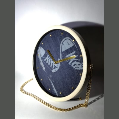 Orologio da scrivania unico con sneakers incise su jeans, cornice in ecopelle bianca, lancette dorate e tracolla in metallo. Stile originale per casa, ufficio o regalo speciale.