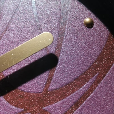 Primo particolare: L'orologio lilla con ghirigori viola scuro è un'eccellente aggiunta all'arredamento. La base lilla crea un'atmosfera raffinata, mentre i dettagli intricati aggiungono un tocco artistico. Posizionato con cura, diventa un punto focale di stile e originalità. La combinazione di viola, nero e oro contribuisce a un look sofisticato.