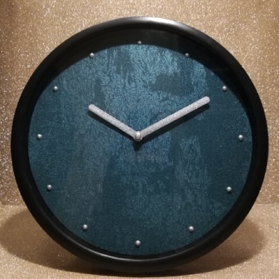L'orologio blu chiaro con effetto cemento unisce serenità e stile industriale. Lancette argentate aggiungono lusso. Ideale come regalo, adatto a vari stili d'arredamento, per un interior design moderno ed elegante.