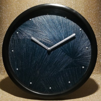 L'orologio blu con ventagli argentati è uno straordinario complemento d'arredo. La fusione di blu, nero e argento crea un look contemporaneo e sofisticato. Un pezzo unico che unisce stile e funzionalità.