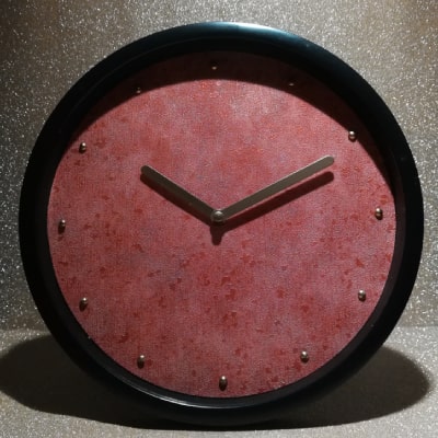 L'orologio da tavolo rosso melange effetto cemento con dettagli lucidi è un capolavoro di design. Il contrasto tra il bordo nero e le lancette dorate crea un look contemporaneo e sofisticato, rendendolo un'idea regalo unica per chi ama l'originalità.