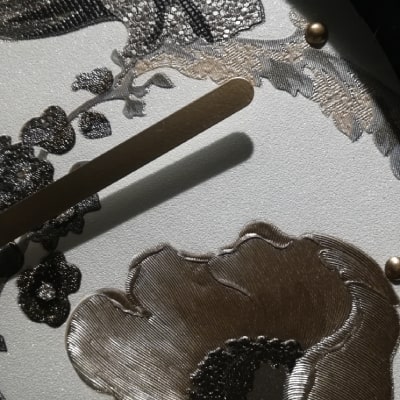 Secondo particolare: L'orologio da scrivania bianco con fiori madreperla in nero, argento e dorato è una bomboniera elegante e un complemento d'arredo raffinato. La combinazione di bianco madreperla e dettagli cromatici crea un ambiente di lusso e stile.